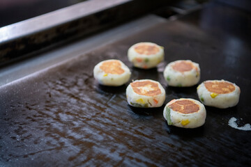 Okazuya potato vegetable hash cooking on flat black grill griddle