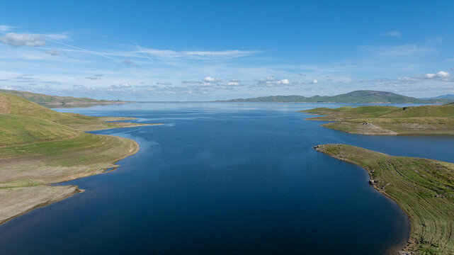 Aerial drone view of full San Luis Reservoir lake looking east