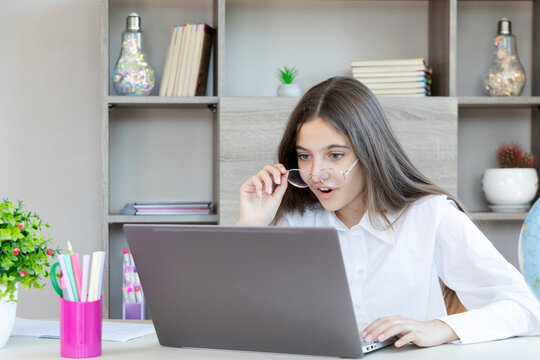 Surprised young girl looking at laptop screen. - Powered by Adobe