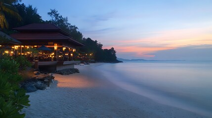 Obraz premium 78. A wide-angle view of Pavilion Pha Leuang Resort at dusk, with glowing lights along the beach and calm waters