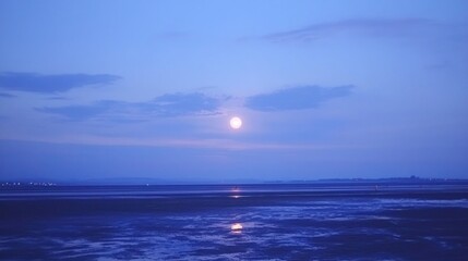 Fototapeta premium Full moon over a tranquil bay at twilight.