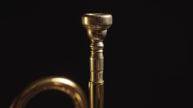 Close up of a trumpet rotating against a black background