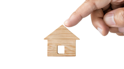 Hand holding wooden house keychain symbolizing home