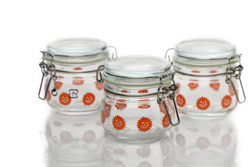 Vintage glass jars with charming orange flowers on display, showcasing timeless design and functionality