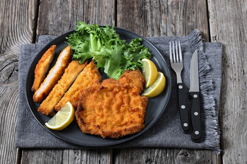 Pork Milanese with lettuce and lemon on a plate