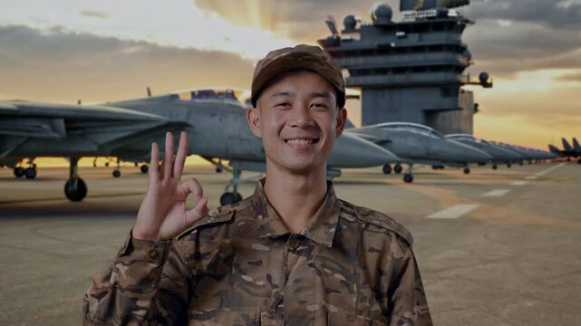 Close Up Of Asian Man Soldier Smiling And Showing Okay Gesture To Camera While Standing On Aircraft Carrier