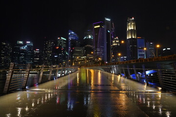 Obraz premium Marina Bay Sands lights up Singapore’s skyline at night with its glowing towers and rooftop, showcasing stunning modern architecture above the shimmering Marina Bay. 