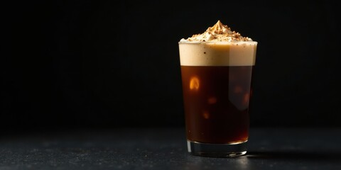 A Refreshing Iced Coffee Beverage Topped with Sweet Cream and a Sprinkle of Spice in a Clear Glass