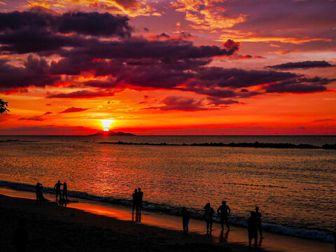 A breathtaking sunset paints the sky with vibrant colors over the waters of a beach in Nasugbu, Batangas, Philippines.