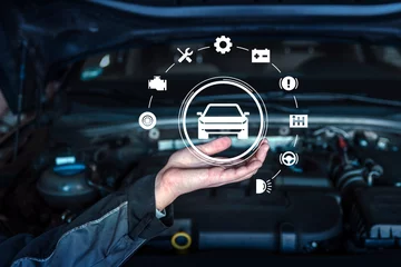 A mechanics hand holding virtual automotive icons including a car, battery, and wrench, displayed above a car engine, symbolizing vehicle diagnostics, maintenance, and repair concepts