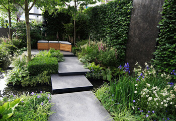 An enclosed garden with seating and water feature