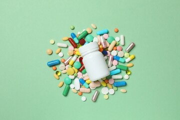 Various pills with  medicine bottle on color background