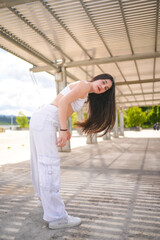 Woman bending while choreographing urban music in a park