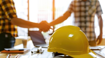 Office handshake, hard hat foreground, construction deal