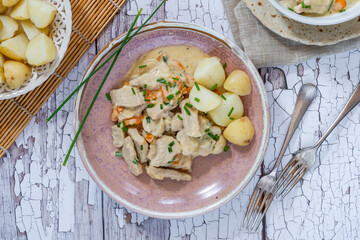Pork in creamy mushroom sauce with boiled baby potatoes