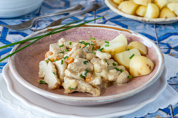 Pork in creamy mushroom sauce with boiled baby potatoes