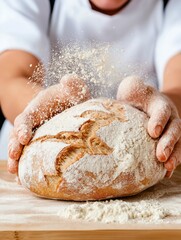Asian female baker dusting flour on a handcrafted loaf in a bright kitchen setting during daytime hours