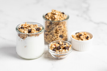 granola with chocolate, yogurt with granola in a glass jar