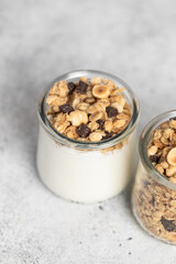 granola with chocolate, yogurt with granola in a glass jar