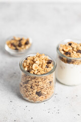 granola with chocolate, yogurt with granola in a glass jar