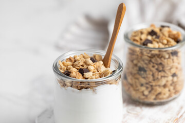 granola with chocolate, yogurt with granola in a glass jar