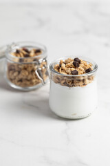 granola with chocolate, yogurt with granola in a glass jar