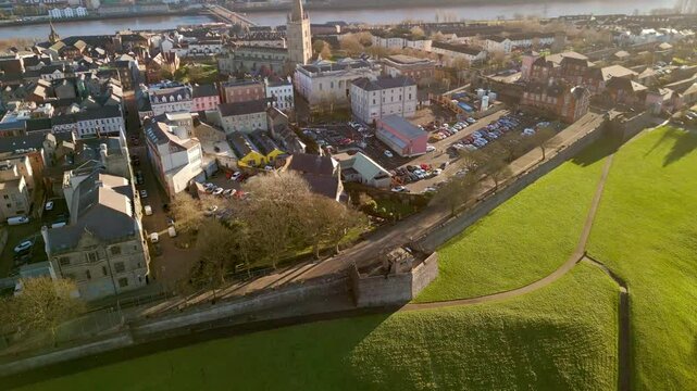 Wide aerial of The City Walls in Derry-Londonderry. The camera sits high in the air and moves towards the Walled City. Filmed in 4K, 60fps and with Rec709 color.