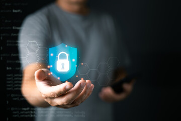 A person holds a glowing digital shield with a lock icon, symbolizing cyber security and data protection, surrounded by hexagonal patterns and soft futuristic lighting.