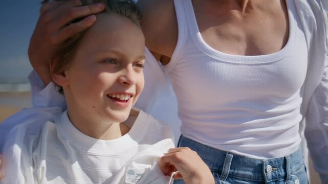 Smiling boy bonding mother sharing joyful moment on sunny beach closeup. 
