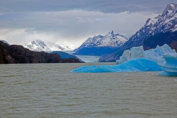 Distant view of Grey Glacier flowing into Lago Grey surrounded by mountains in Torres del Paine