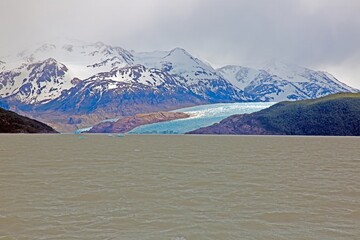 Distant view of Grey Glacier flowing into Lago Grey surrounded by mountains in Torres del Paine