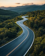 Fototapeta premium Winding paved asphalt road through lush green mountains scenic landscape nature photography early morning light