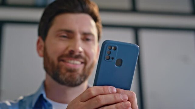 Happy startuper chatting online looking smartphone screen closeup. Smiling man