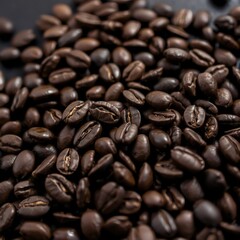 Fototapeta premium Close-up of freshly roasted coffee beans spread across a dark wooden surface. The rich, glossy beans contrast beautifully with the wood, creating a premium, earthy atmosphere. Created with AI.