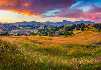 Fantastic summer sunrise in Carpathian countryside. Breathtaking morning scene of Yasinya village with dark overcast. Beauty of countryside concept background.