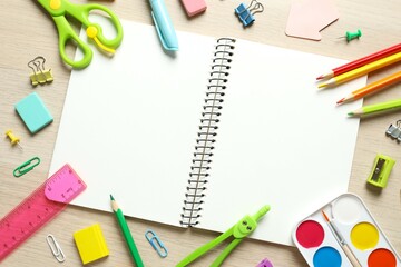 Flat lay with school stationery with notebook on wooden background, top view