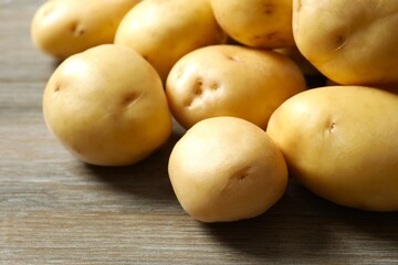 Young potatoes. Fresh potatoes on a wooden background. Harvesting collection. organic, freshly dug potatoes. Agricultural background. Vegan. Vegetables.Place for text.Copy space