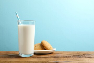 Glass of milk with cookies on table