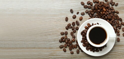 Cup with coffee and coffee beans on wooden background 
