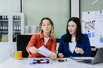 Fototapeta premium Diverse designer collaborate on project analysis with financial graphs. Strategic teamwork and insights drive company growth and success.