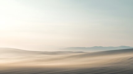 Fototapeta premium Desert landscape with sand dunes and mountains under a hazy sky.