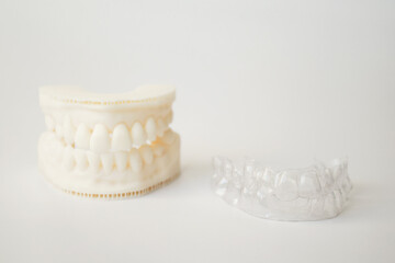 Transparent aligner and model or muld of human jaws. Invisible essix retainer or orthodontic silicone trainer or dental caps. Dental services for correcting the bite and aligning teeth