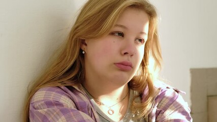 A close-up of a sad young student leaning against a wall, her face reflecting stress and loneliness. This image highlights themes of teenage depression, academic pressure, and emotional struggles.