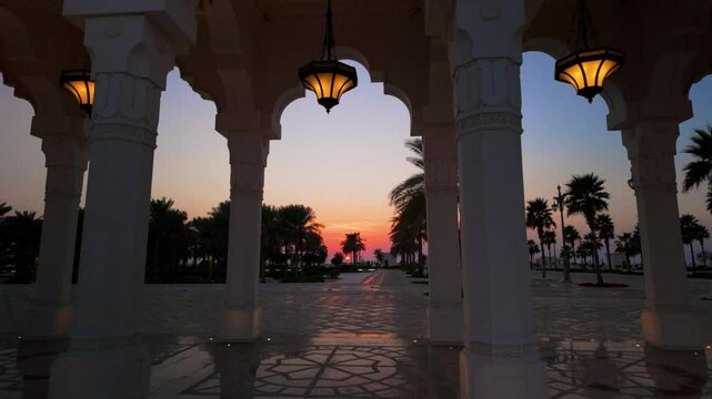 Sunset at a resort or palace plaza garden with palm trees in a tropical climate