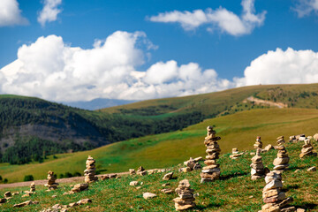 A field of rocks is scattered across a grassy hillside. The rocks are arranged in a way that...