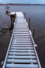 Obraz premium Snow-covered wooden pier extending over a winter lake