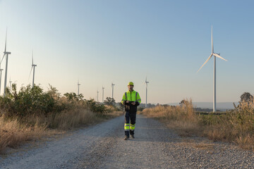 Obraz premium Survey Team Alternative energy for future. Engineers survey and checking wind turbines in sunset. Wind Turbine Renewable energy technology and sustainability.