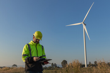 Survey Team Alternative energy for future. Engineers survey and checking wind turbines in sunset. Wind Turbine Renewable energy technology and sustainability.