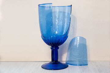 Broken blue glass on a white wooden background. Two pieces.