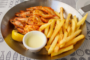 Potato chips and grilled prawns with sauce in bowl